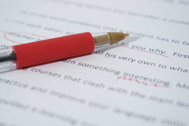 Red pen on paper with red editing marks 