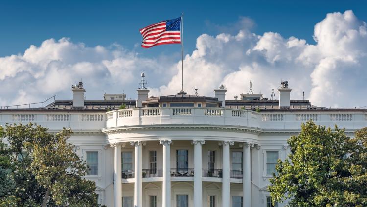 White House in Washington D.C. with prominent American flag 