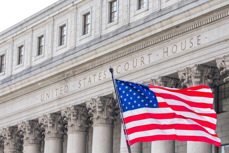 American flag flying before a US court house.