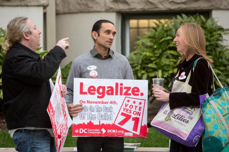 People holding legalize marijuana signs