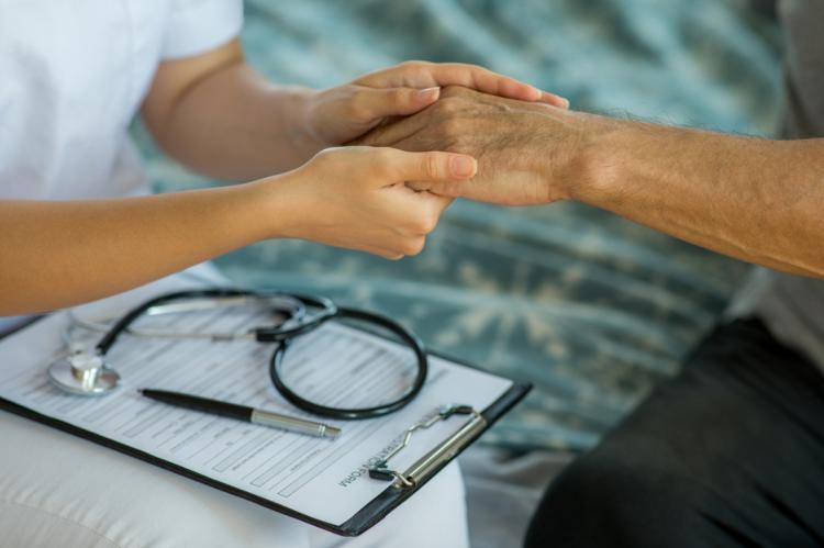 Nurse holding patient's hand
