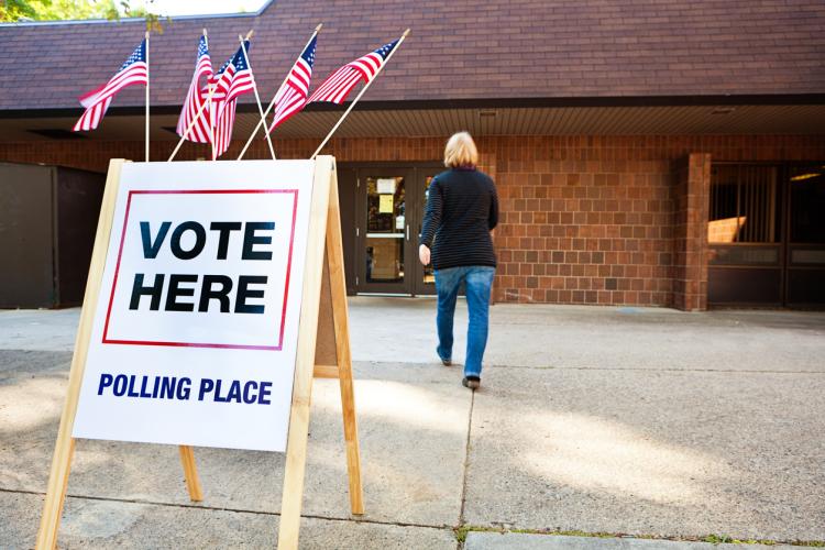 woman voter entering a voting polling place for USA government election