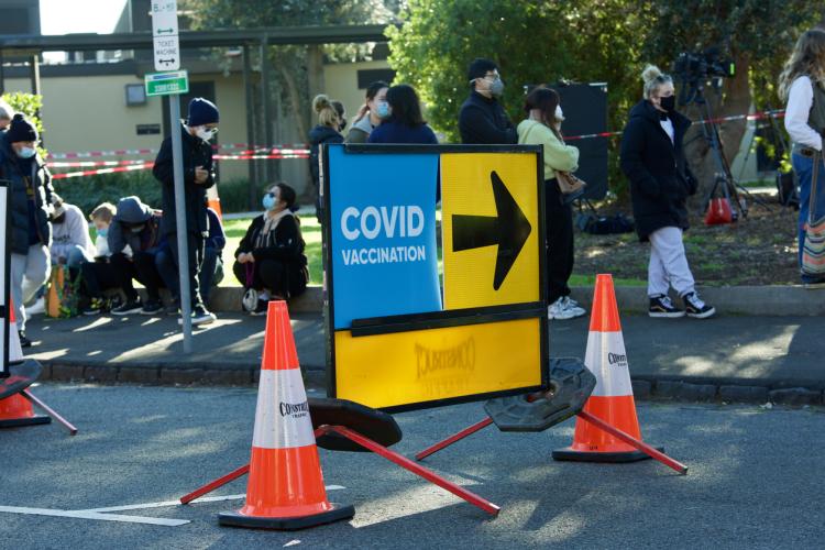 Covid-19 vaccination sign and arrow at walk in vaccine clinic.