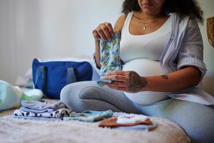 Pregnant woman sorting baby clothes