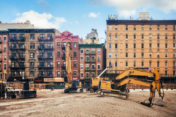 yellow bulldozers standing on large construction site in lower manhattan in New York in front of old facades
