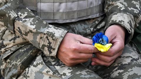 Ukrainian cadet holding artificial flower with Ukrainian flag colors
