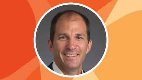 Headshot of Zoltan Hajnal in a circle against SSN's orange texture file