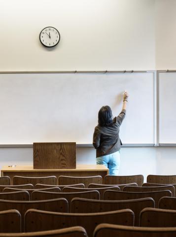 Classroom with teacher writing on white board