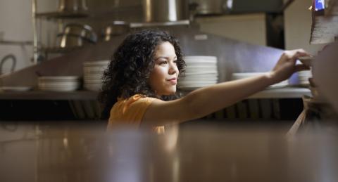 Latina working in the kitchen of a restaurant