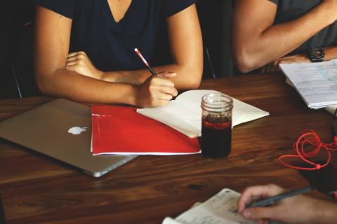 People sat at a table, writing together