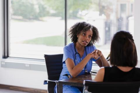Female doctor sitting with female patient