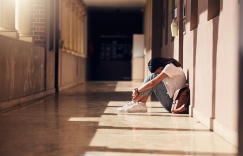 Sad college student on floor of university hallway