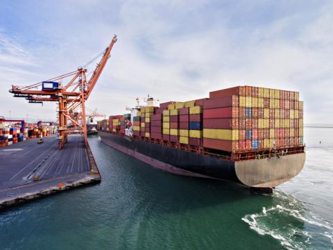 Cargo ship with shipping containers on top at port