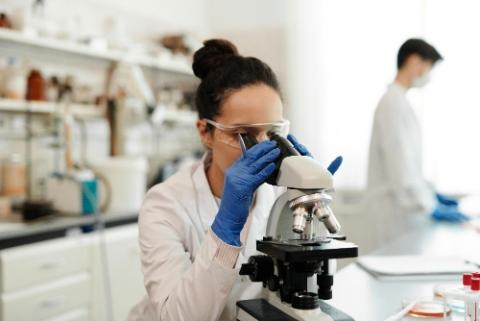Researcher, Scientist looking through a microscope