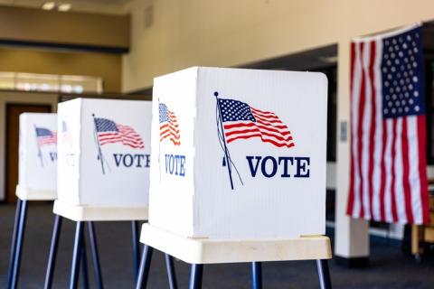 Empty ballot boxes with "vote" and American flags 