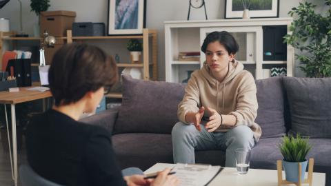 Teenager talking to therapist on a couch