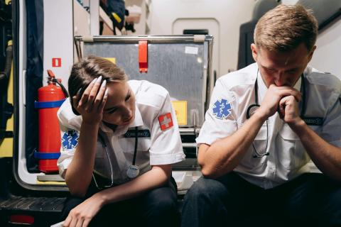 First responders sitting on ambulance feeling emotional 