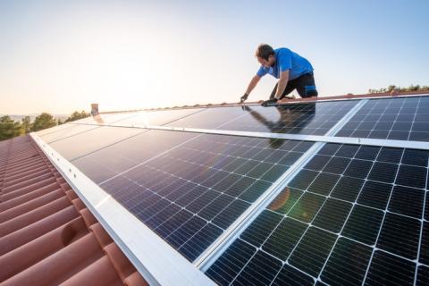 person installing solar panels on a roof 