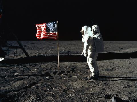 astronaut on the moon with an american flag