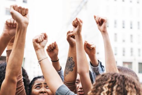 group of people protesting, fists in the air 