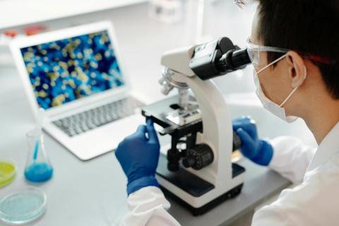 scientist looking in microscope