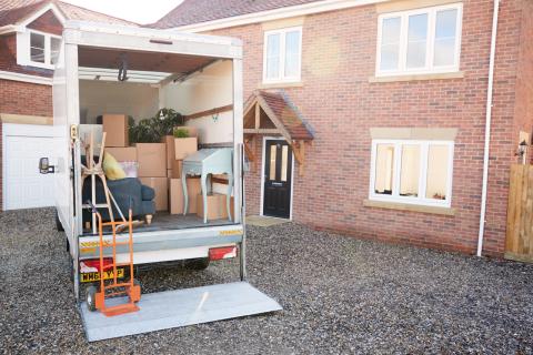 moving truck with moving boxes in front of a house