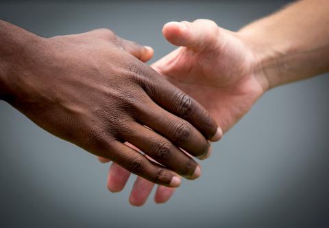 Black hand and white hand shaking