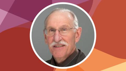 Headshot of Michael Howard against SSN's red-purple texture file background