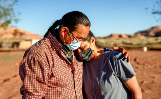 Native American husband and wife hugging with masks on