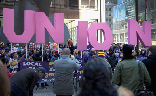 SEIU event with members holding up individual letters spelling out "UNION" while wearing SEIU shirts 